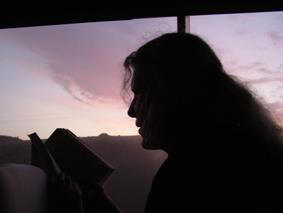 Colette Dowell in Lima Peru reading book on bus